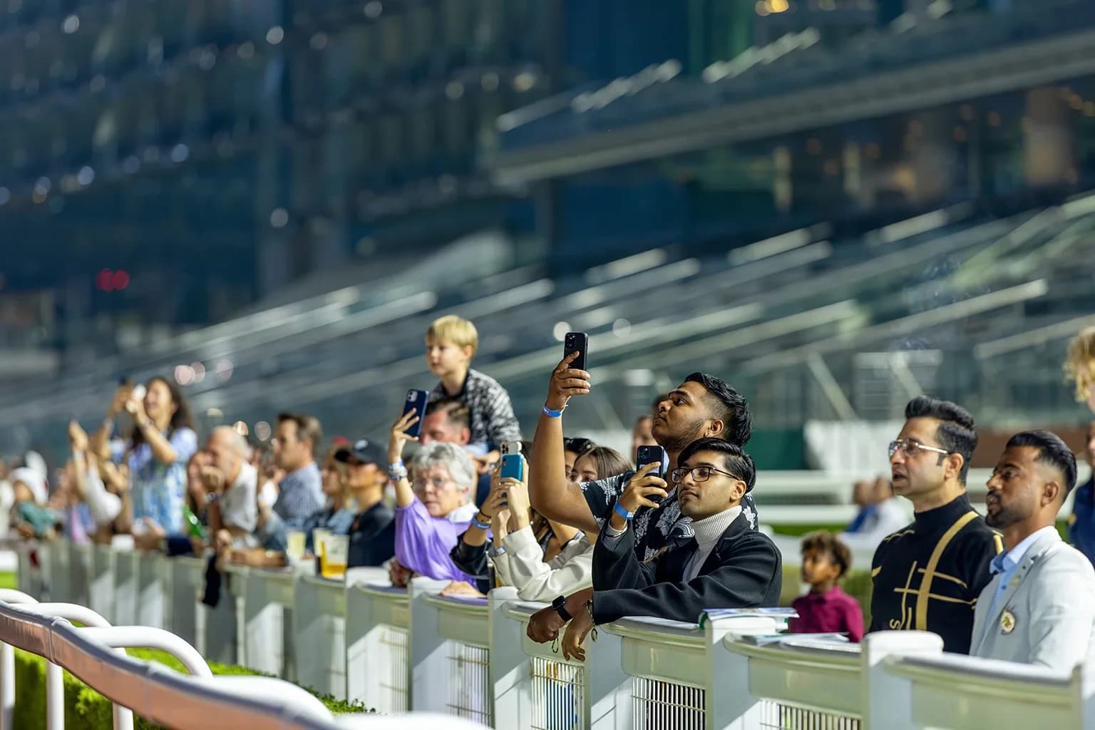 Racegoers photographing the action at Meydan